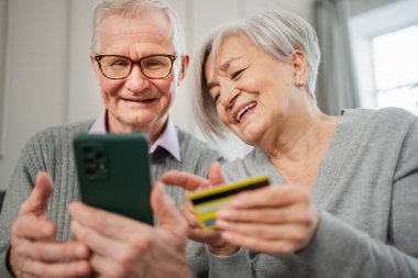 Üst sınıf erkek kadın alışverişi, akıllı telefondan kredi kartıyla yapılıyor. İnternetten satın alan yaşlılar kredi kartı bilgilerini evlerinde giriyorlar. Çevrimiçi alışveriş servisi ekommerce