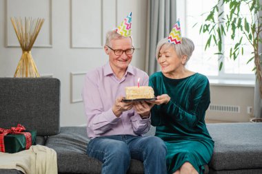 Bir dilek tut. Parti şapkalı son sınıf aile çifti evde birlikte doğum günü kutluyor. Yaşlı kadın doğum günü pastasında yanan mumları üflüyor. Yaşlı adam karısına mutlu yıllar diliyor.