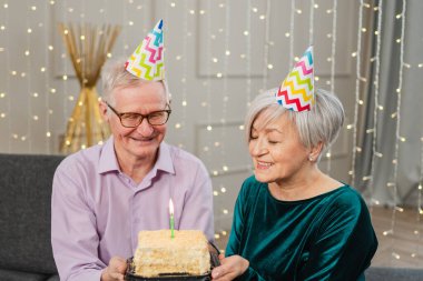 Bir dilek tut. Parti şapkalı son sınıf aile çifti evde birlikte doğum günü kutluyor. Yaşlı adam doğum günü pastasında yanan mumları üflüyor. Yaşlı kadın kocana mutlu yıllar diliyor.