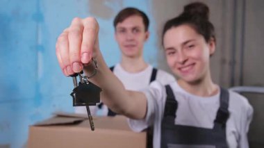 Kendi evime. İpotek yeri değiştirme konsepti. Yeni First House 'un anahtarı mutlu çiftte. Aile taşınma günü. Karı koca müşteriler gayrimenkul satın alırlar taşınma kutusunda anahtarlarını gösterirler
