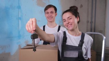 Kendi evime. İpotek yeri değiştirme konsepti. Yeni First House 'un anahtarı mutlu çiftte. Aile taşınma günü. Karı koca müşteriler gayrimenkul satın alırlar taşınma kutusunda anahtarlarını gösterirler