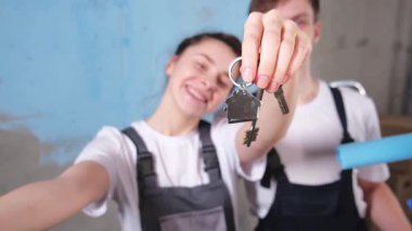 Kendi evime. İpotek yeri değiştirme konsepti. Yeni First House 'un anahtarı mutlu çiftte. Aile taşınma günü. Karı koca müşteriler gayrimenkul satın alırlar taşınma kutusunda anahtarlarını gösterirler