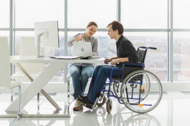 İş arkadaşları, kadın sandalyeye oturanlar, engelli çalışanlar için. Şirket kurma ekibi birlikte çalışıyor. Şirket profesyonel takımı proje fikirlerini tartışıyor