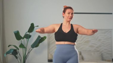 Fitness antrenmanı. Evde spor yapan bir kadın. Artı ev içinde spor egzersizi yapan beden bir kadın. Spor giyimli kız kilo vermek için ağırlık çalışması yapıyor. Spor ve zindelik