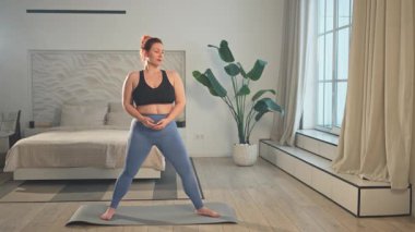 Yoga fitness antrenmanı. Evde yoga yapan bir kadın. Artı ev içinde yoga minderiyle spor egzersizi yapan beden bir kadın. Spor giyim bölümündeki kız kilo vermek için antrenman yapıyor. Spor ve zindelik