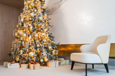 Klasik Noel dekore edilmiş oturma odası. Modern klasik iç tasarım dairesi rahat koltuğu ve beyaz altın süslemeli Noel ağacı. Evde Noel arifesi