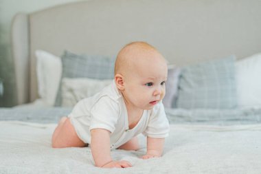 Mutlu bebek. Yatak odasında yatakta sürünen, gülen yüzlü, yeni doğmuş şirin bir kız. Bebek dinleniyor, evde battaniyeye uzanmış oynuyor. Annelik mutlu çocuk bakımı konsepti