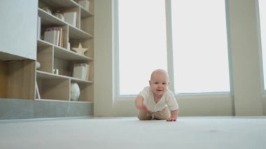 Mutlu bebek. Yatak odasında yerde sürünen, gülen yüzlü, yeni doğmuş şirin bir kız. Bebek dinleniyor. Oturma odasında oynuyor. Evde. Annelik mutlu çocuk bakımı konsepti