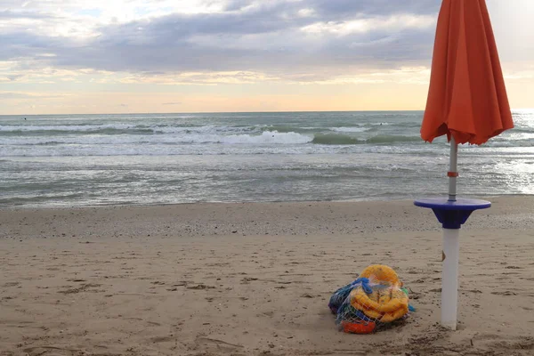 children\'s umbrella games on the sand of the sea