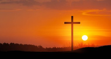 Christian cross on hill outdoors at sunrise. Resurrection of Jesus. Concept photo.