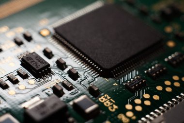 Boş bir çipe odaklı yeşil bilgisayarlı devre kartının makro fotoğrafı.