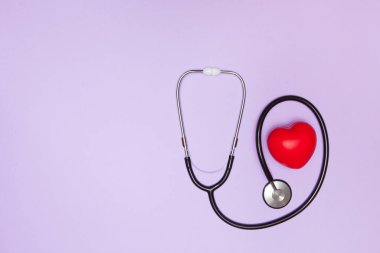 Stetoskop, kırmızı kalp ve boşluk mor arkaplan üzerine yazı için, düz yatış. Sağlık sigortası kavramı.