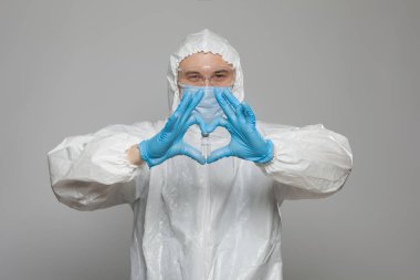 Closeup of vial to vaccinate in scientific virologist hand for immunization. Scientific virologist. Biologist in protective suit and blue gloves. Vaccination concept.