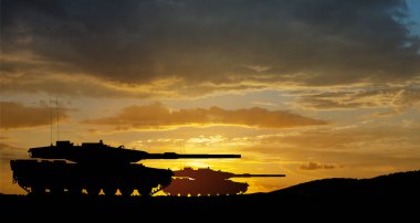 Silhouettes of army tanks at sunset sky background. Military machinery.