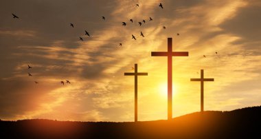 Christian cross on hill outdoors at sunrise. Resurrection of Jesus. Concept photo.