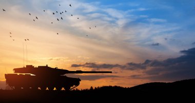 Silhouette of army tank at sunset sky background. Military machinery.
