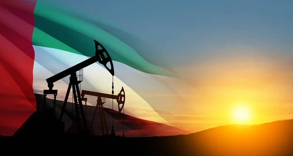 The change in oil prices caused by the war. Oil prices are rising because of the global crisis. Oil drilling derricks at desert oilfield with UAE flag. Crude oil production from the ground.