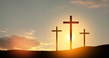 Christian cross on hill outdoors at sunrise. Resurrection of Jesus. Concept photo.