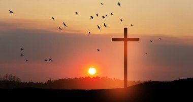 Christian cross on hill outdoors at sunrise. Resurrection of Jesus. Concept photo.