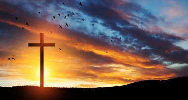 Christian cross on hill outdoors at sunrise. Resurrection of Jesus. Concept photo.