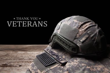 USA military uniform with insignias on old wooden table on black background. Memorial Day or Veterans day concept.