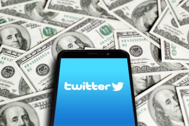 Twitter logosu akıllı telefon ekranında dolarların arka planında. Twitter bir mikroblog ve sosyal ağ hizmetidir. Elon Musk Twitter satın alma anlaşmasını tamamladı. Moskova, Rusya - 27 Ekim 2022.