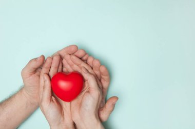 Erkek ve kadın elleri kırmızı kalp, sağlık hizmeti, bağış ve aile sigortası konsepti, dünya kalp günü, dünya sağlık günü, CSR sorumluluğu, evlatlık aile, umut, şükran, nezaket, konsept..