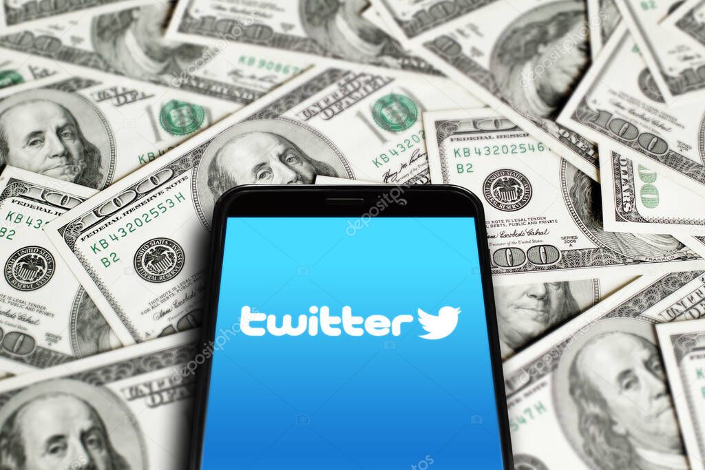 Twitter logo on smartphone screen on background of dollars. Twitter is a microblogging and social networking service. Elon Musk closes Twitter acquisition deal. Moscow, Russia - October 27, 2022.