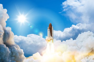 Spaceship lift off. Space shuttle with smoke and blast takes off into space on a background of blue sky. Successful start of a space mission. Elements of this image furnished by NASA.