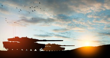 Silhouettes of army tanks at sunset sky background. Military machinery.