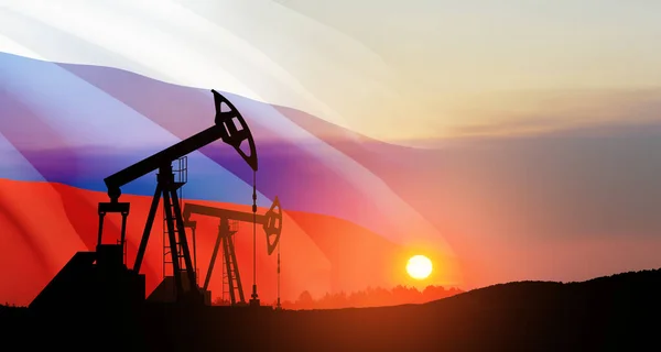 The change in oil prices caused by the war. Oil prices are rising because of the global crisis. Oil drilling derricks at desert oilfield with Russia flag. Crude oil production from the ground.