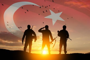 Silhouettes of soldiers on a background of Turkey flag and the sunset or the sunrise. Concept of crisis of war and conflicts between nations. Greeting card for Turkish Armed Forces Day, Victory Day.