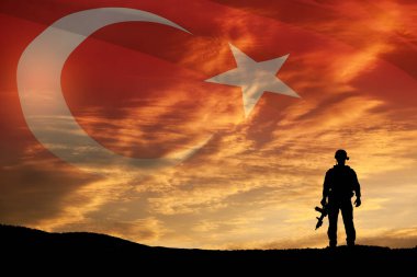 Türkiye bayrağının arka planında asker silueti ve gün batımı ya da gün doğumu. Savaş krizi kavramı ve uluslar arasındaki çatışmalar. Türk Silahlı Kuvvetleri Günü için tebrik kartı, Zafer Günü.