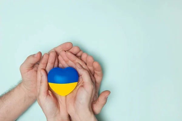 stock image Heart with print the national flag of ukraine in female and male hands. Flat lay. Copy space.