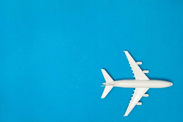 飛行機モデル 青の背景に白い飛行機 旅行休暇のコンセプト 夏の背景 フラットレイアウト トップビュー コピースペース — ストック写真