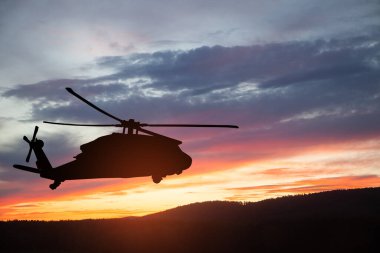 Gün batımının arka planında helikopter siluetleri. Gaziler Günü için tebrik kartı, Anma Günü, Hava Kuvvetleri Günü. ABD kutlaması.