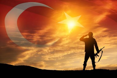 Silhouette of soldier on a background of Turkey flag and the sunset or the sunrise. Concept of crisis of war and conflicts between nations. Greeting card for Turkish Armed Forces Day, Victory Day.