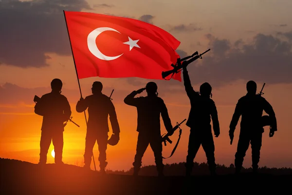 Silhouettes of soldiers with Turkey flag against the sunrise or sunset. Concept of crisis of war and conflicts between nations. Greeting card for Turkish Armed Forces Day, Victory Day.