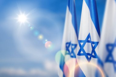 Israel flags with a star of David over cloudy sky background. Patriotic concept about Israel with national state symbols. Banner with place for text. clipart