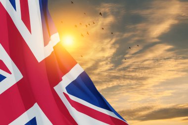 National flags of United Kingdom with flying birds on sunset sky background. Background with place for your text. 3d rendering.