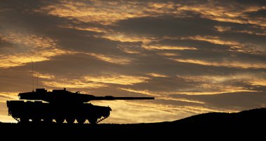 Silhouette of army tank at sunset sky background. Military machinery.