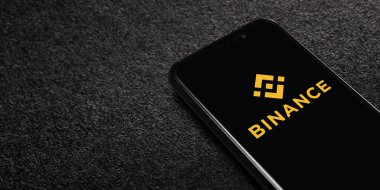 Smartphone with Binance logo on black textured background. Binance is a cryptocurrency exchange. Moscow, Russia - November 1, 2022.
