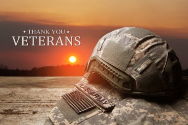 USA military uniform with insignias on old wooden table on sunset sky background. Memorial Day or Veterans day concept.