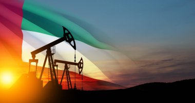 The change in oil prices caused by the war. Oil prices are rising because of the global crisis. Oil drilling derricks at desert oilfield with UAE flag. Crude oil production from the ground.