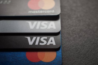 Visa kredi kartlarının ve kredi kartlarının yakın çekimleri koyu bir arkaplana yerleştirilmiş. Makro fotoğraf. Moskova, Rusya - 14 Mart 2022.