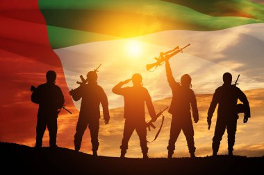 Silhouettes of soldiers on background of UAE flag and the sunset or the sunrise. Concept of national holidays. Commemoration Day.