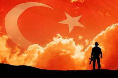 Türkiye bayrağının arka planında asker silueti ve gün batımı ya da gün doğumu. Savaş krizi kavramı ve uluslar arasındaki çatışmalar. Türk Silahlı Kuvvetleri Günü için tebrik kartı, Zafer Günü.