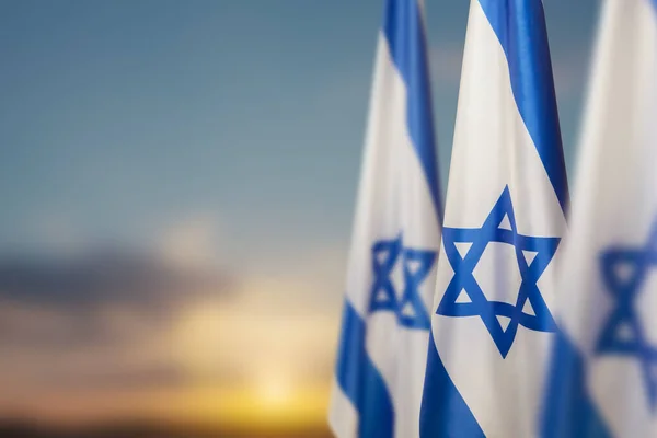 イスラエルは日没にダビデの星を背景に曇った空にフラグを立てます 国家のシンボルを持つイスラエルについての愛国的な概念 テキストのための場所とバナー — ストック写真