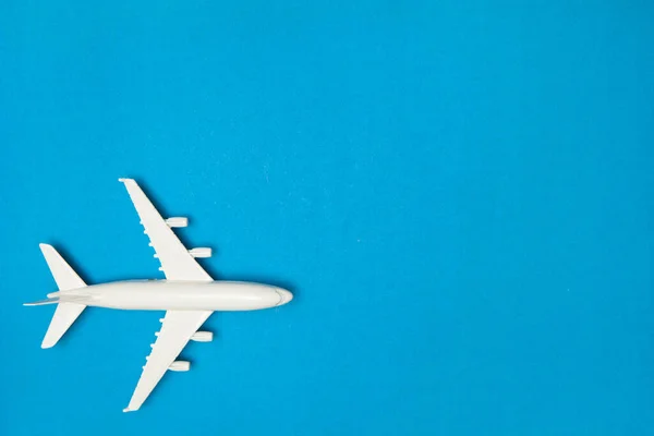 飛行機モデル 青の背景に白い飛行機 旅行休暇のコンセプト 夏の背景 フラットレイアウト トップビュー コピースペース — ストック写真