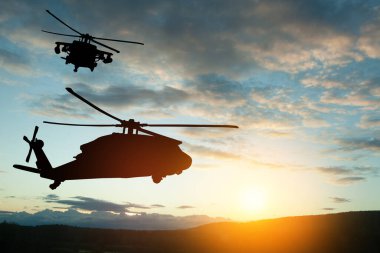 Gün batımının arka planında helikopter siluetleri. Gaziler Günü için tebrik kartı, Anma Günü, Hava Kuvvetleri Günü. ABD kutlaması.